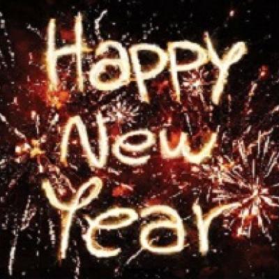 Happy New Year written with sparklers against a black background