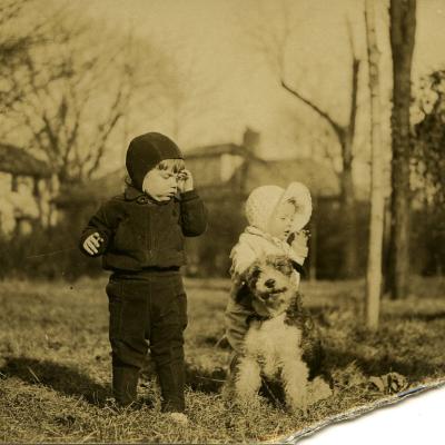 Black and white image of a small girl with a dog