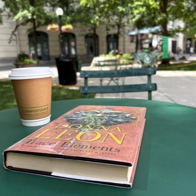 Reading outside at a cafe with coffee.