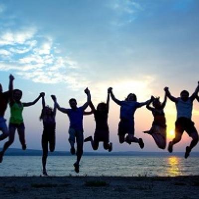 Silhouette of people holding hands and jumping.