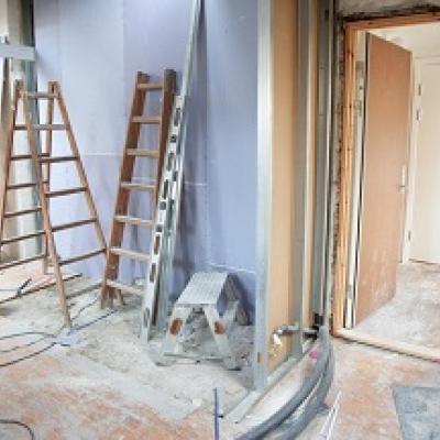Interior space with ladders and drop cloths.