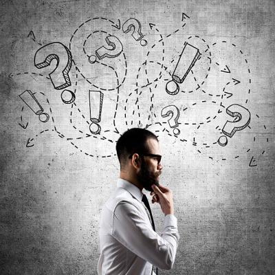 Man with hand on his chin with question marks floating about his head.