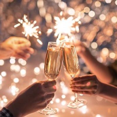 Hands holding champaigne glasses and sparklers.