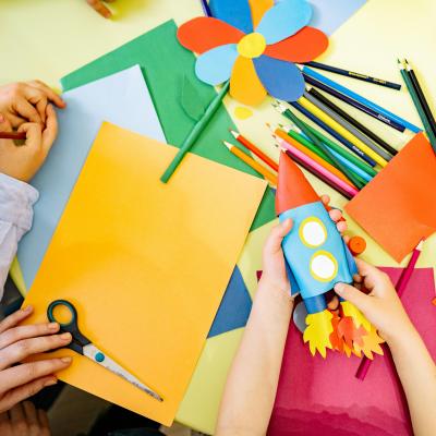 Overhead view of people's hands working on crafts.
