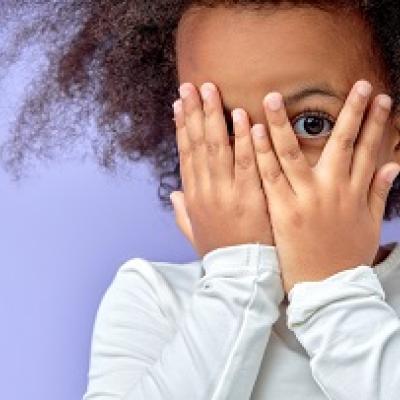 Child covering eyes with her hands.