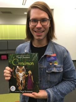 Andrew Palmer holding up book "Cinnamon" by Neil Gaiman.