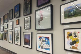 Wall with many framed pieces of art.