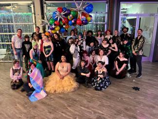 Group of young people in party attire posing for a picture.