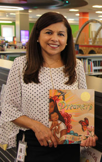 Staff person Pat Bashier holding a book