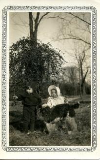 Black and white photo of a young girl with a dog.