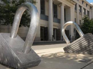 Sculpture depicting two large padlocks emerging from the ground. 